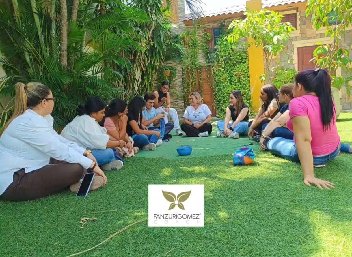 Grupo sentado en círculo sobre el césped durante un taller